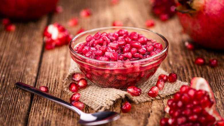 pomegranate seeds scooped into bowl