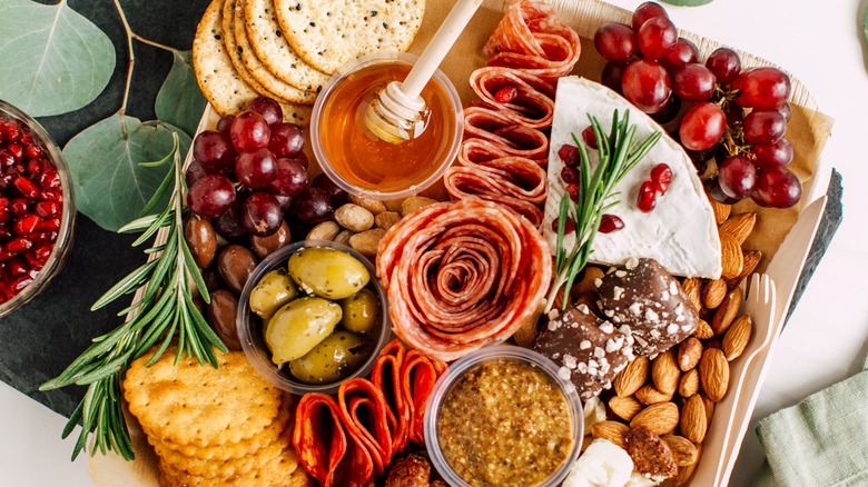 Charcuterie board with meats, olives, cheese, honey