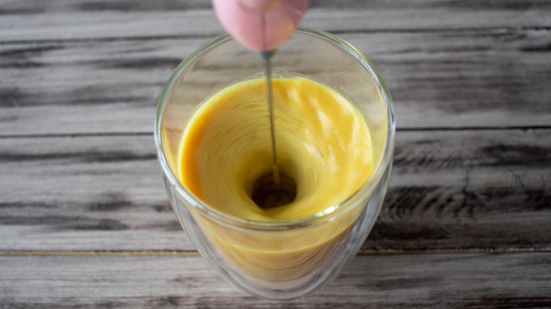 Milk frother creating whirlpool in glass