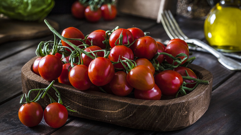 Cherry tomatoes on the vine in a wood bowl