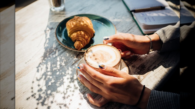 hands holding cup of coffee