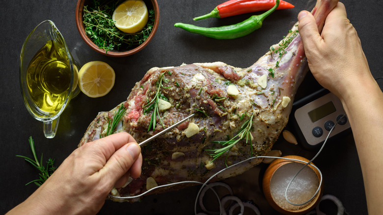 Inserting temperature probe in leg of lamb