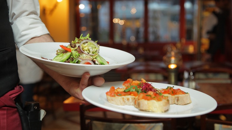 server holding plates of food