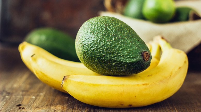 Avocado sitting on three bananas