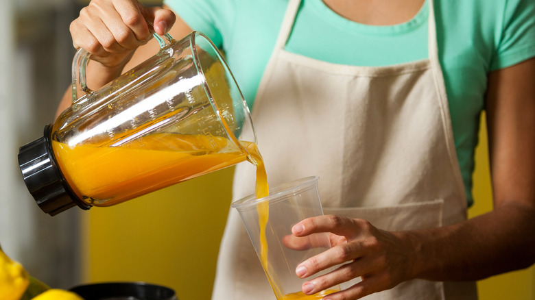 pouring carrot juice in glass