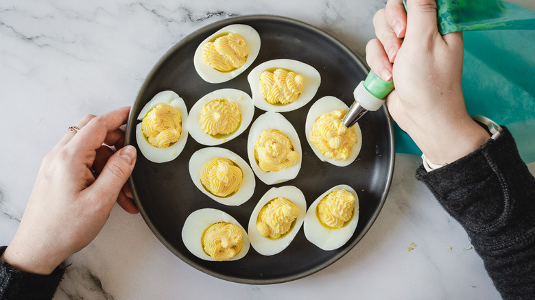piping filling into deviled eggs