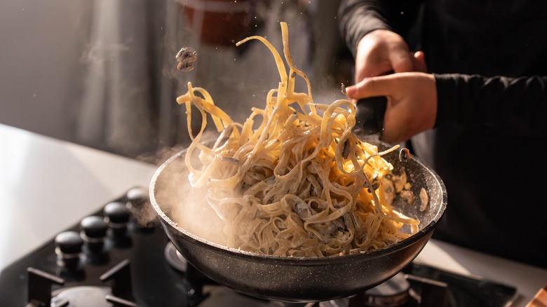 Tossing pasta in a pan