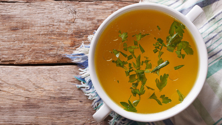 A bowl of fresh beef broth with parsely