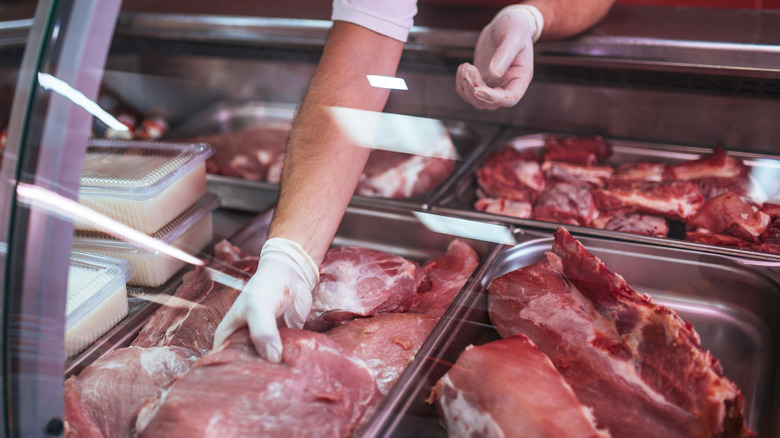 grabbing meat in a grocery store