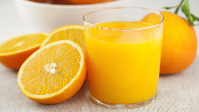 orange juice in glass with sliced oranges