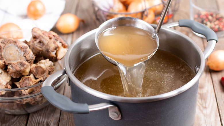 pot of chicken broth with ladle