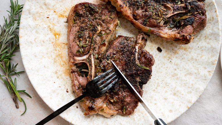 cutting lamb shoulder on plate 