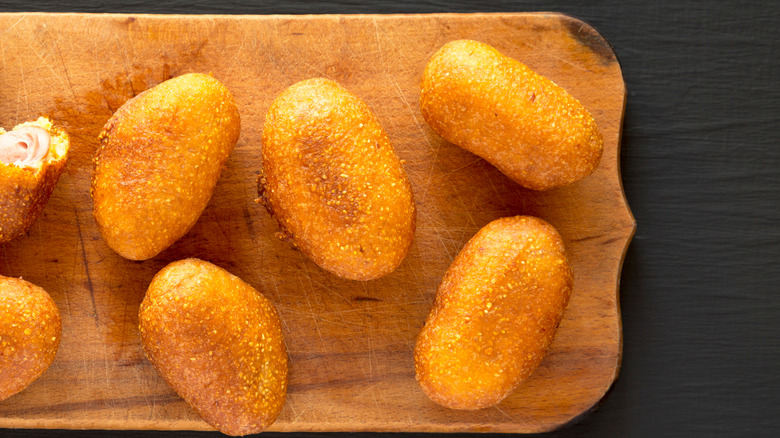 Mini corn dogs on cutting board