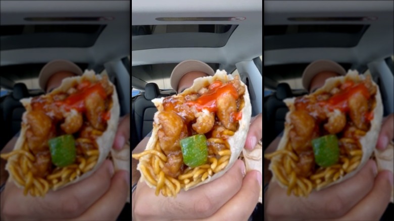 A person holding up a panda express burrito