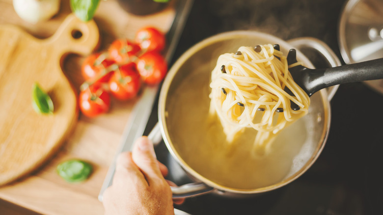 Pasta in pot of water with spoon