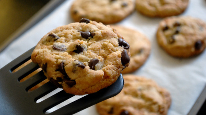 chocolate chip cookies on a baking sheet and spatula