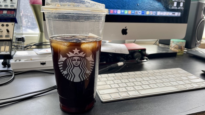 partially drunk cup of coffee with ice.