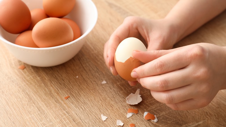 Person peeling hard-boiled egg