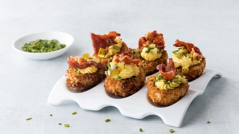 Deep fried deviled eggs topped with bacon and chives