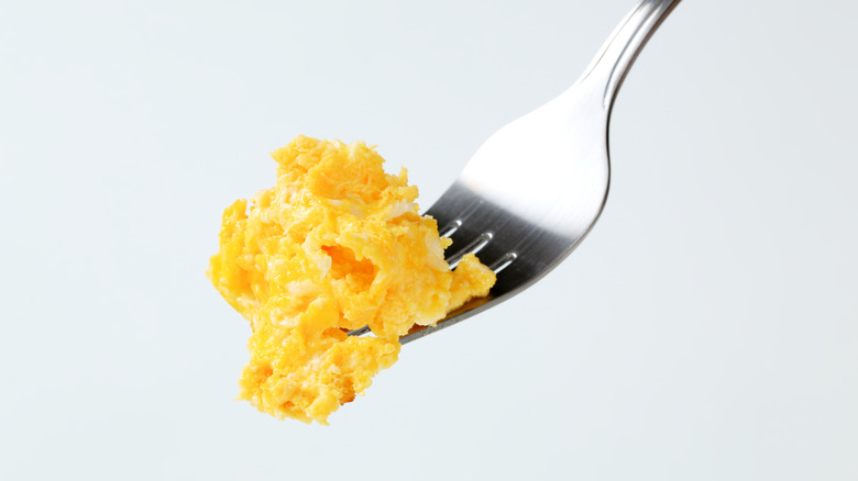 Bite of scrambled eggs on a fork