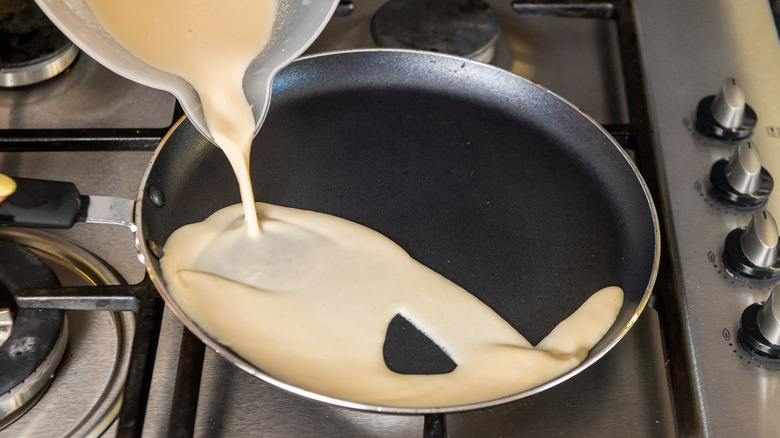crepe batter being poured into pan 