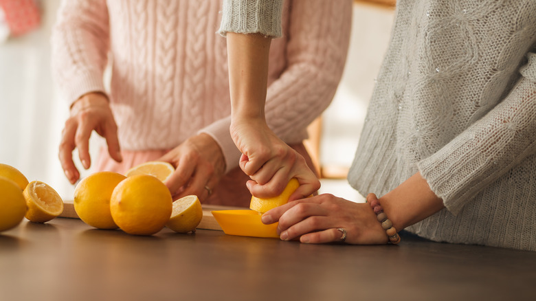 Two people juicing lemons