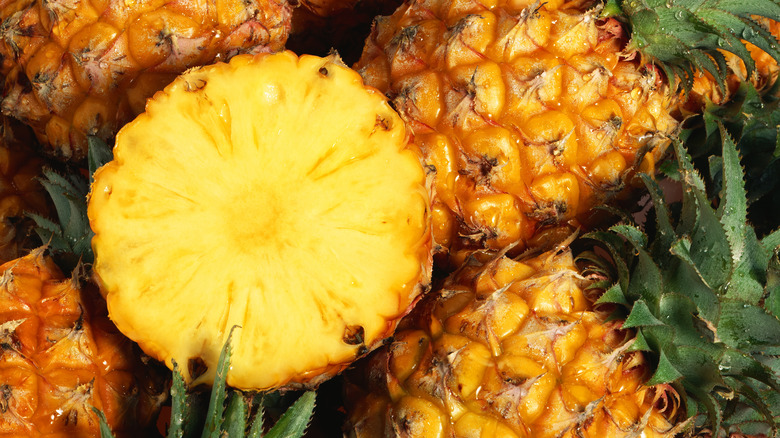 Sliced pineapple on top of whole pineapples