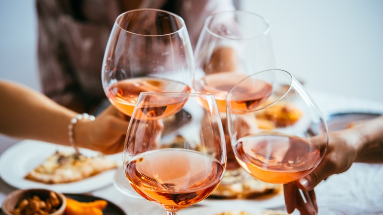 Toasting four glasses of rose