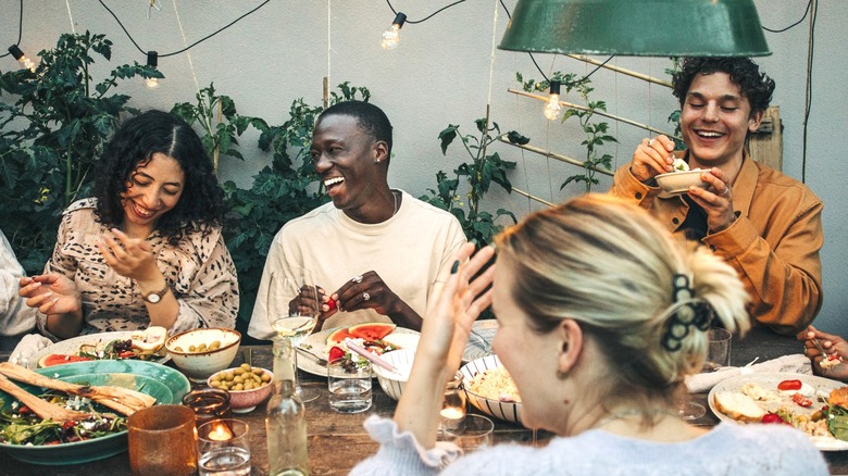 dinner party guests eating at a table