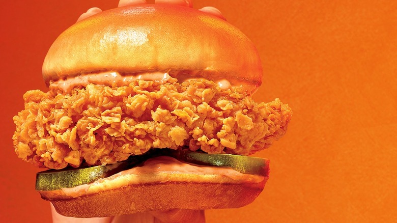 Hand holding Popeye's Ghost Pepper Chicken Sandwich