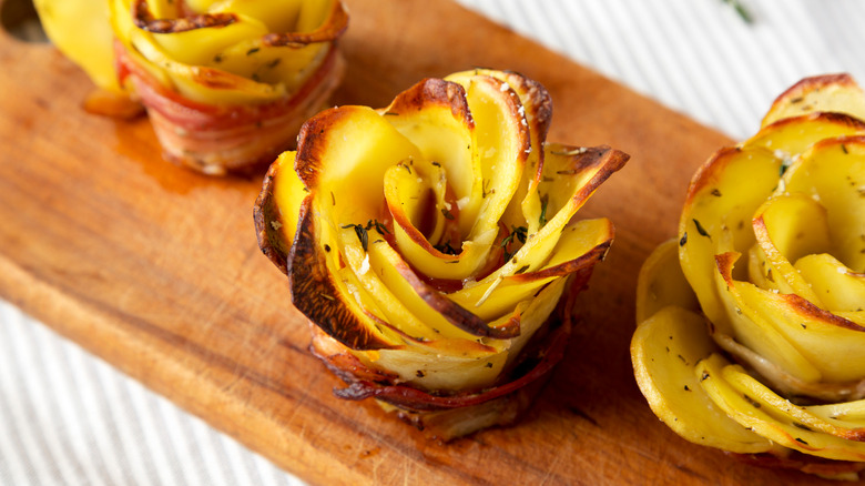 Three potato roses on a chopping board