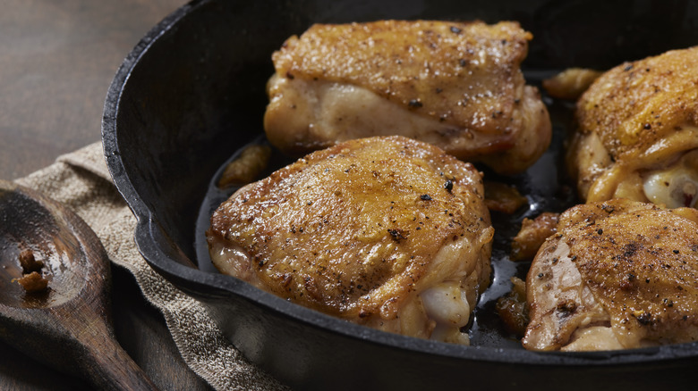 chicken thighs cooking in skillet