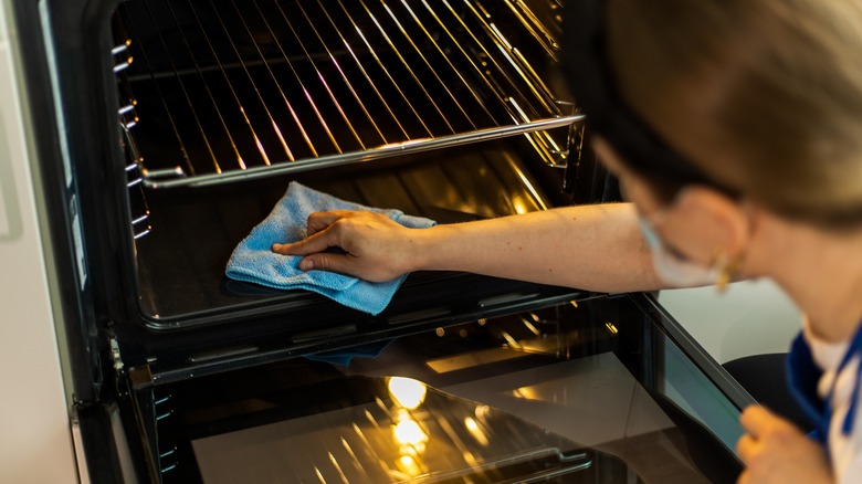 Person wiping down the oven