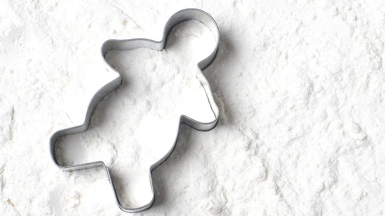 Cookie cutter on flour background 