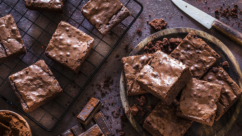 Plate of brownies next to brownies on a cooling rack