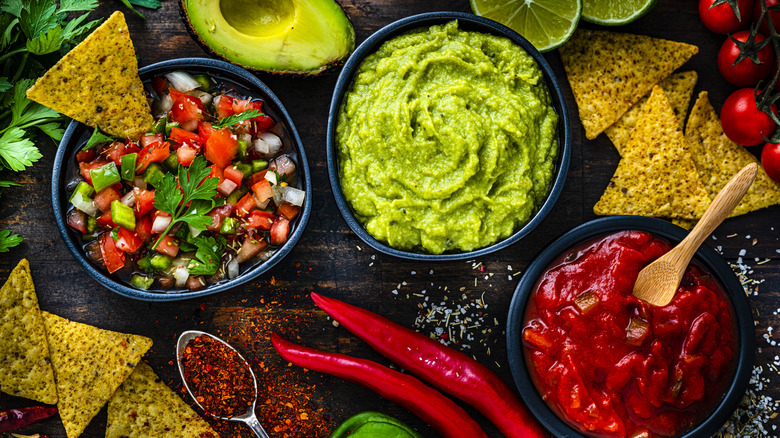 Bowls of salsa, guacamole and hot sauce