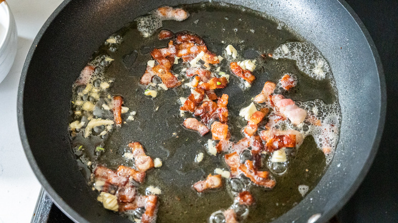 bacon, oil, and garlic simmering in pan