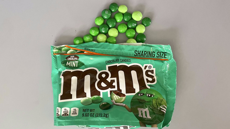 Green dark chocolate M&M's spilling from bag