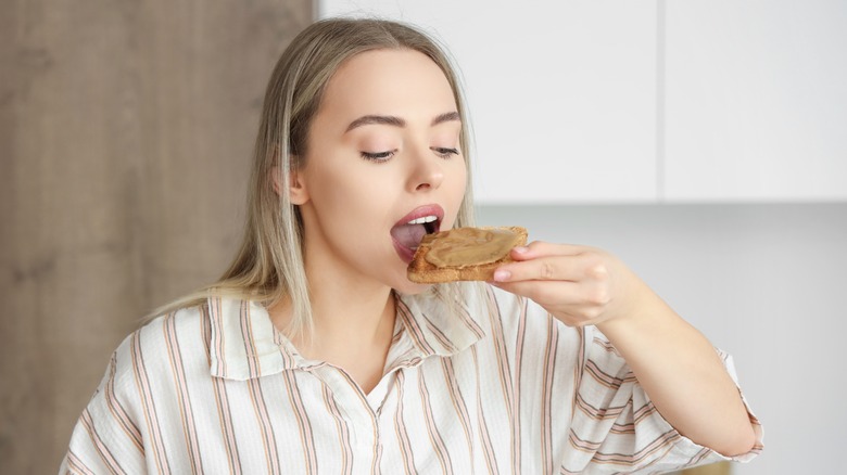 woman eating peanut butter toast