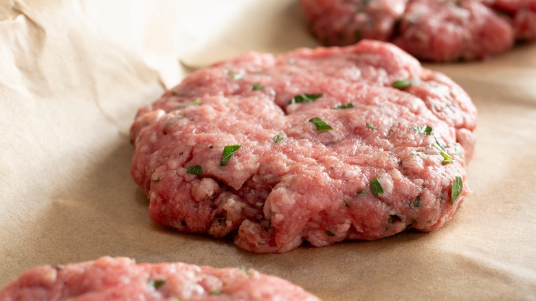 Raw beef patties on paper