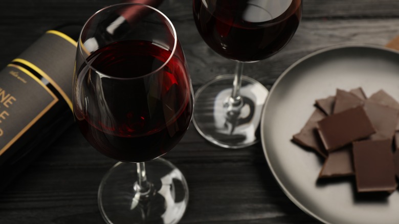 two glasses of wine and chocolate served on a plate