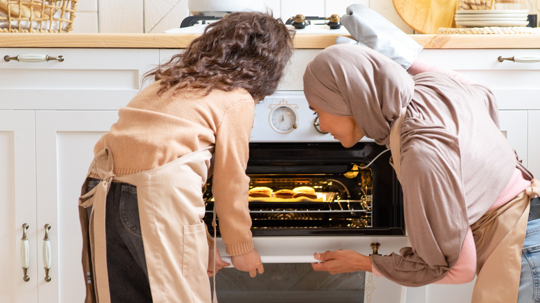 Mother and daughter reheating muffins 