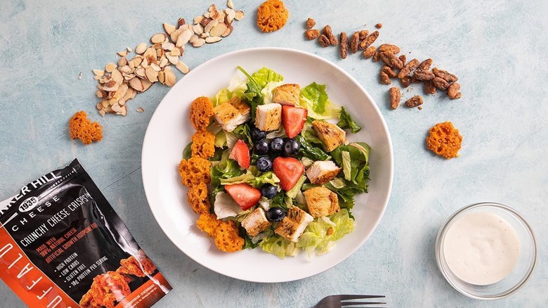 salad with cheese crisps and ingredients around bowl