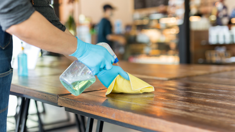 Food worker cleaning table