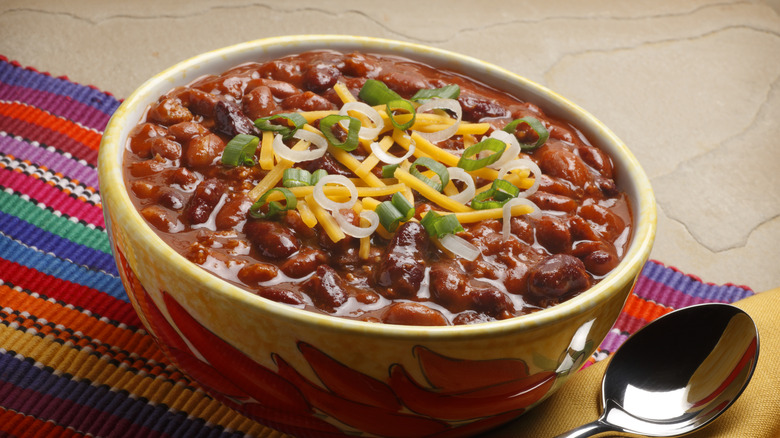 Bowl of chili with cheese and scallions