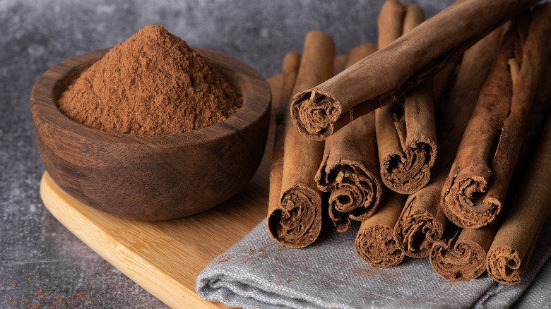 Cinnamon in powder and stick form on cutting board