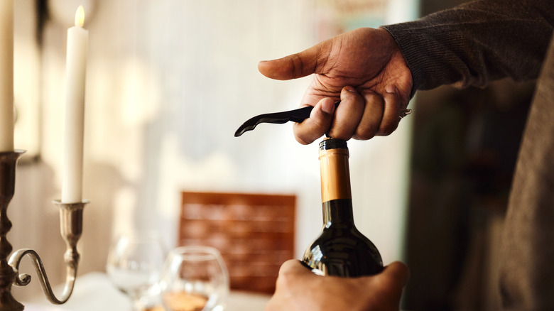 A wine bottle being opened