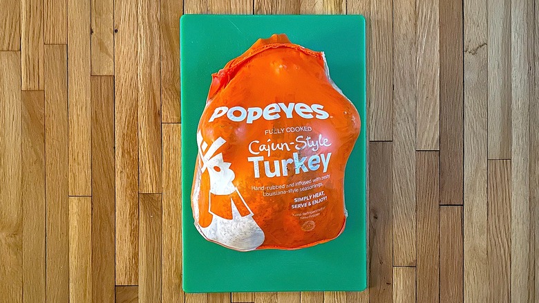 Popeyes signature Cajun-Style Turkey in its package on green cutting board