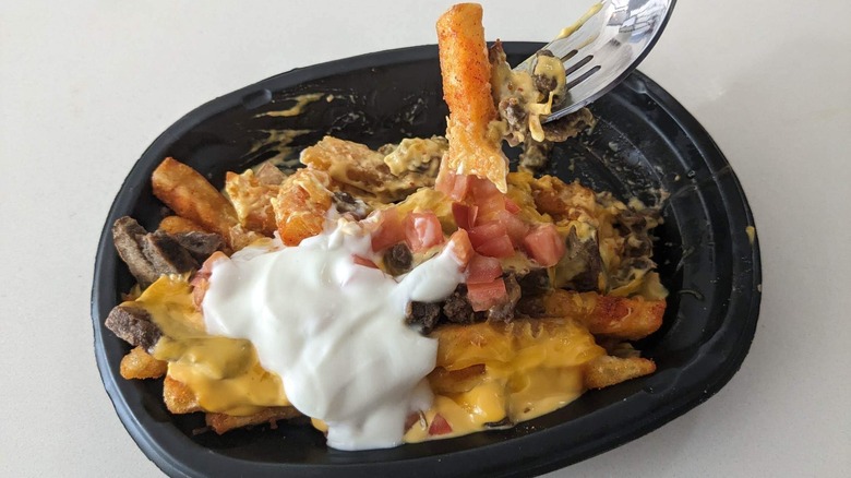 Taking a fork full of steak yellowbird nacho fries