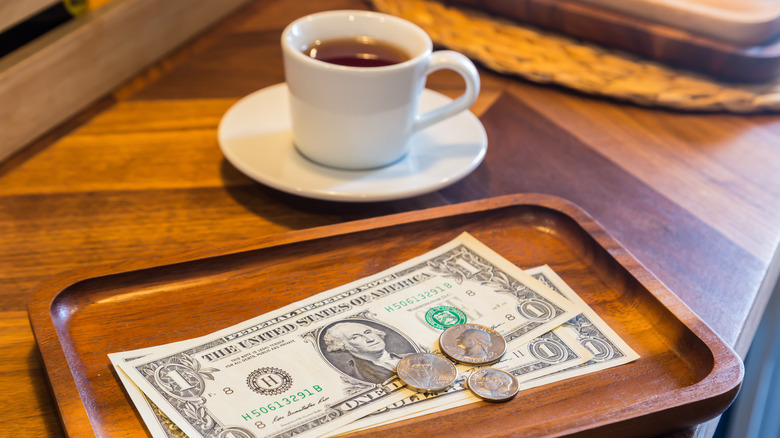 Dollar and change on table with espresso 